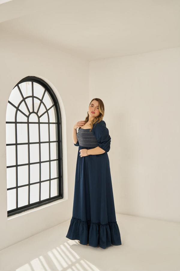 Plus size cotton smocked maxi dress with puff sleeves and tiered hem, worn by model in size XL in blue colour.