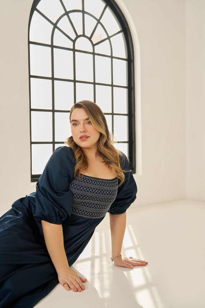 Plus size cotton smocked maxi dress with puff sleeves and tiered hem, worn by model in size XL in blue colour.