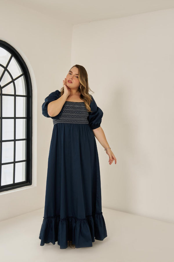 Plus size cotton smocked maxi dress with puff sleeves and tiered hem, worn by model in size XL in blue colour.