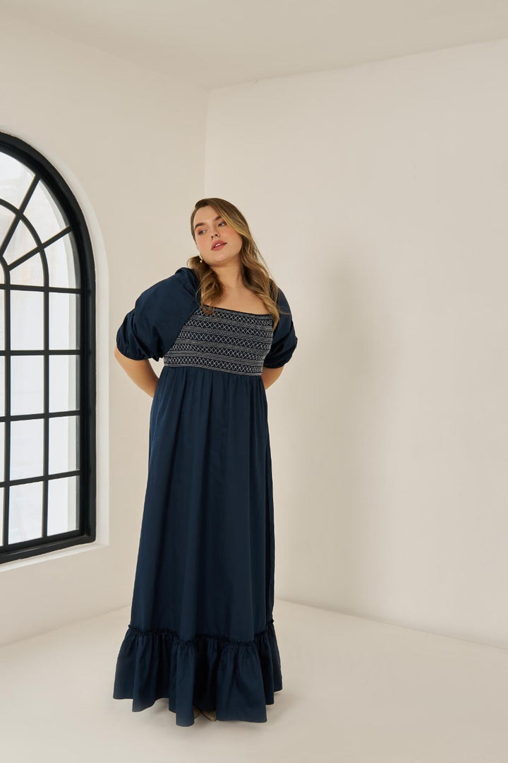 Plus size cotton smocked maxi dress with puff sleeves and tiered hem, worn by model in size XL in blue colour.