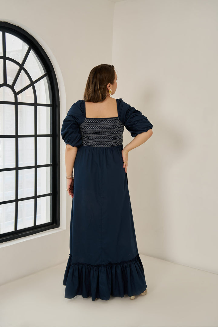 Plus size cotton smocked maxi dress with puff sleeves and tiered hem, worn by model in size XL in blue colour.
